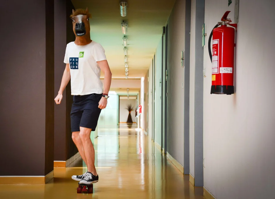 Kolega z profiq týmu s koňskou hlavou na hlavě a zároveň jedoucí na skateboardu