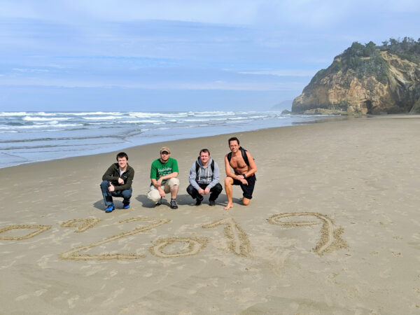 Čtyři zaměstnanci profiqu na služební cestě ve státě Washington v USA, na fotce na výletě u oceánu.